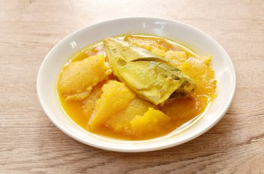 Baharatlı ananaslı haşlanmış uskumru ve tabakta ekşi çorba.