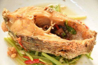 Kızarmış pirzola Nil Tilapia ya da mango balığı. Soya sosu ve kereviz dilimi tabakta. 