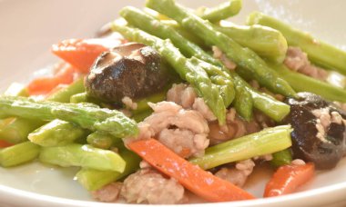 Kızarmış kuşkonmaz ve siyah mantar ile istiridye soslu pirzola. 