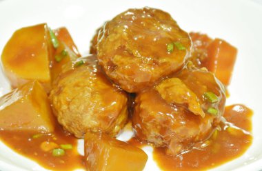 Kızarmış tavuk bifteği ve havuç. Tabakta kırmızı sos güveci.