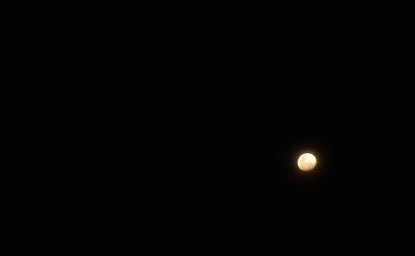 通过在夜间的背景下散布云彩来遮蔽月亮 — 图库照片