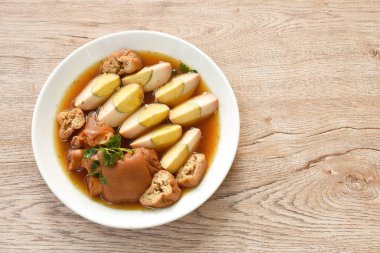 Haşlanmış yarım yumurta, sebzeli tofu kahverengi çorba ve tabakta domuz budu. 