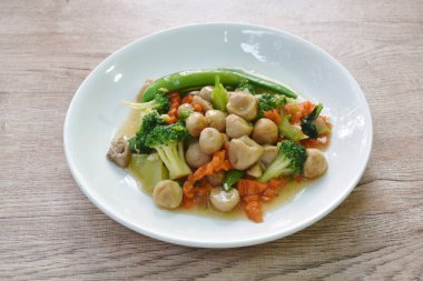 Kızarmış brokoli, yeşil bezelye ve saman mantarlı vejetaryen yemeği tabakta karıştır. 