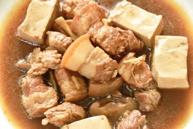 Kaynamış domuz eti ve yeşil sebze çorbası tabakta tofu. 