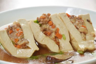 Buharda pişmiş beyaz tofu doldurulmuş et suyu soslu et püresi.