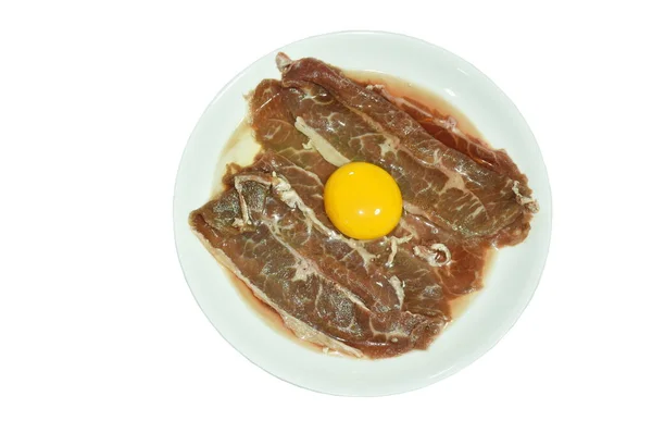 白地に隔離された皿の上に盛り付けられた生の卵をスライスビーフシャンク — ストック写真
