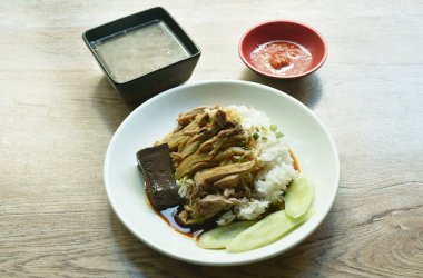 Haşlanmış ördek eti ve kahverengi Çin bitkisi çorbası üzerine pirinç sosu, acılı sos ve çorba.