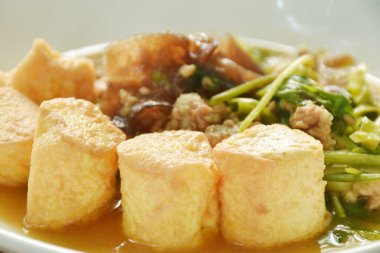 Kızarmış yumurtalı tofu, domuz püresi ve tabakta kereviz mantarı.