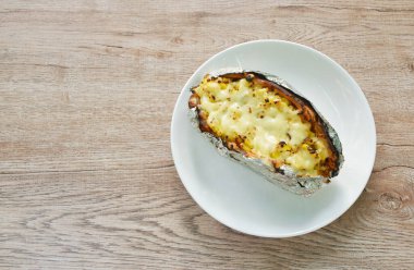 Japon tatlı patatesi pişirirken mısır tohumunu peynirle doldururken tabakta folyo