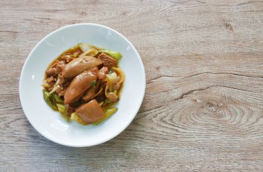 Uzun acı biberli kızarmış tavuk ve tabakta soğan.