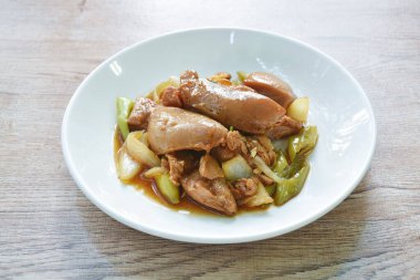 Uzun acı biberli kızarmış tavuk ve tabakta soğan.