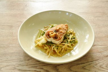 Kızarmış kırmızı levrek dilimlenmiş soya sosu ve kereviz tabakta. 