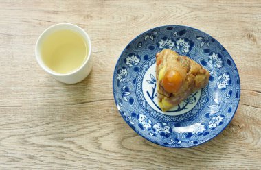 Çin Duanwu Festivali 'nin domuz eti ve tuzlu yumurtalı pilav buharı. İki tabak sıcak çay fincanında.