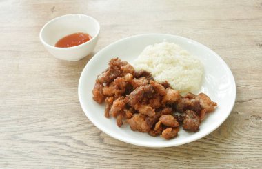 Kızarmış tuzlu domuz eti ve pilav. Baharatlı biber sosu.