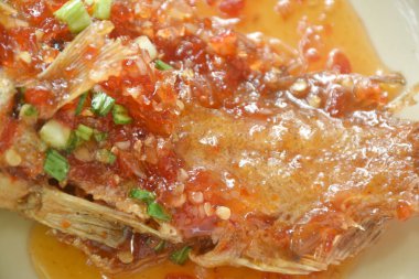 Kızarmış kırmızı orfoz balığı tabakta tatlı ve baharatlı acı biber sosu  