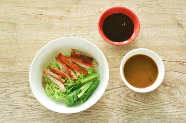 Çin yeşim eriştesi, kızarmış ördek eti ve lahana, tatlı soya sosunu kaseye bandırıyor. 