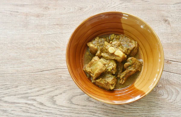 Stock image spicy fried pork bone with herb in curry sauce on bowl 