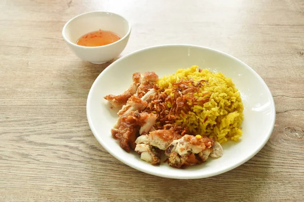 Kızarmış tavuk ve biryani pilavı tabakta köri soslu tatlı acı biber soslu. 