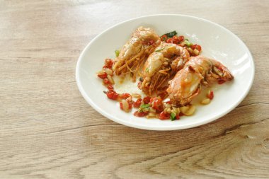 Tuzlu ve acı soslu kızarmış nehir karidesi.