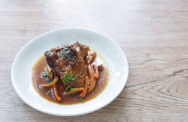 Buharda pişirilmiş tavuk budu ve havuç ve soya soslu çorba tabakta.