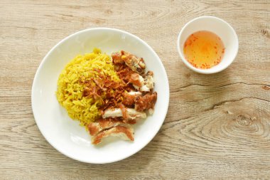 Kızarmış tavuk ve biryani pilavı tabakta köri soslu tatlı acı biber soslu. 