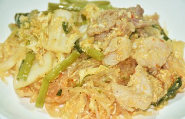 Kızarmış cam şehriye domuz eti ve sebzeli tavuk eti tabakta sukiyaki sosu.