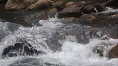 Su, Tayland 'daki Kho Chong Lom şelalesinde taştan taşa dökülüyor.