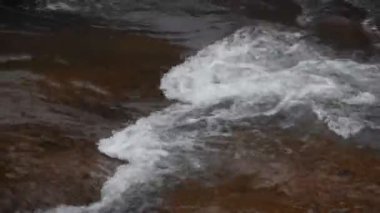 Su, Tayland 'daki Kho Chong Lom şelalesinde taştan taşa dökülüyor.