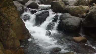 Su, Tayland 'daki Kho Chong Lom şelalesinde taştan taşa dökülüyor.