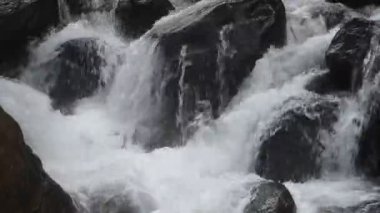 Su, Tayland 'daki Kho Chong Lom şelalesinde taştan taşa dökülüyor.