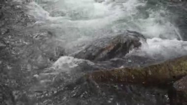 Su, Tayland 'daki Kho Chong Lom şelalesinde taştan taşa dökülüyor.