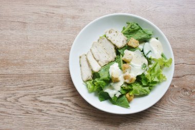 Kaynamış karabiberli Sezar salatası tavuk göğsü tabakta çıtır ekmek