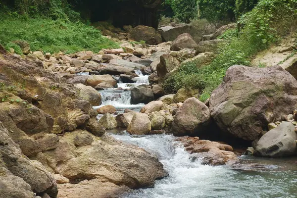 Su, Tayland 'daki Kho Chong Lom şelalesinde taştan taşa dökülüyor.