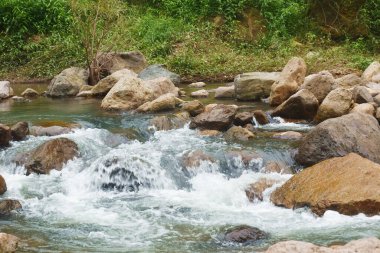 Su, Tayland 'daki Kho Chong Lom şelalesinde taştan taşa dökülüyor.