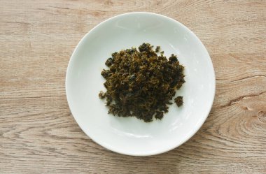 Kızarmış hardal turşusu ya da lahana ve tabakta siyah zeytinyağından yapılmış Gan Lan Cai yemeği.