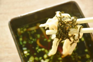 Zaru soba soğuk Japon eriştesi pirzola yosununun üstünde Shoyu sosu dilimlenmiş taze soğan tabağında