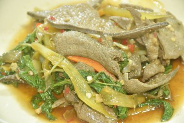 Baharatlı kızarmış domuz ciğeri, soğanlı ve biberli birkaç fesleğen.  