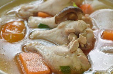 Haşlanmış tavuk budu, havuç ve domates soslu soğan soslu tabakta mantar çorbası.