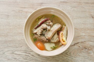 sıcak ve baharatlı domuz kemik demirhindi ve Tay otlar çorba kase üzerinde 