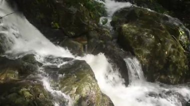 Su, Tayland 'ın kuzeyinde Chet Kod şelalesinde nehir geçidine taş ve kaya döküyor. 