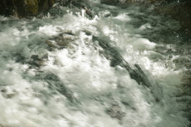 Su, Tayland 'ın kuzeyinde Chet Kod şelalesinde nehir geçidine taş ve kaya döküyor. 