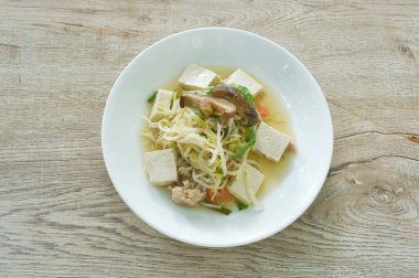 Kızarmış fasulye filizi, dilimlenmiş beyaz tofu ve havuçlu çift domuz pirzolası tabakta mantar.