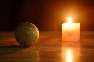 Altın top çifti Noel süslemeleri için mum ışığı ve yeni yıl festivali için siyah zemin