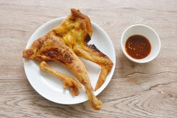 roasted half chop chicken meat wing and leg on plate dipping with spicy sauce