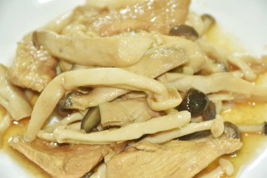 Kızarmış Shimeji mantarı, tavuk göğsü ve soya sosunu beyaz tabakta karıştır.