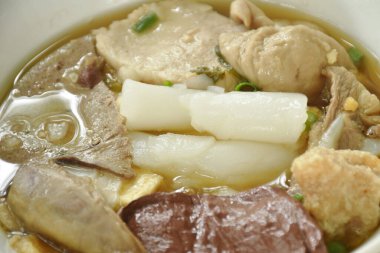 Çin pilavı ezmesi, domuz eti ve bağırsaklar. Kahverengi bir çorba kâsesinde kan. 