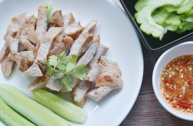 Limonlu sarımsak ve acı soslu ızgara domuz eti sosu tabakta salata.