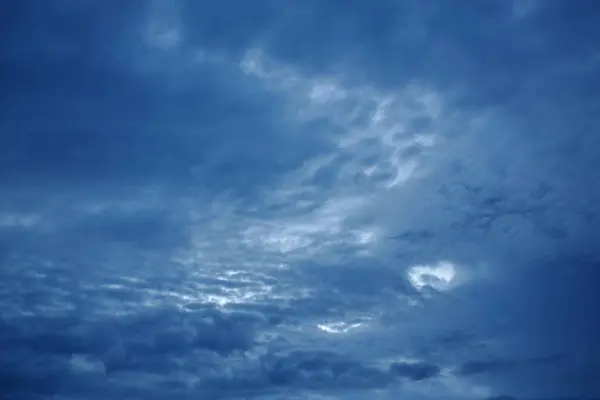dark rain cloud floating and spreading on twilight sky in evening