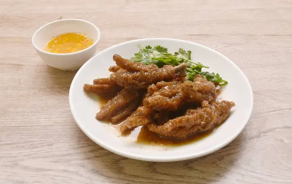 steamed chicken foot in sweet red soybean gravy on plate dipping chili sauce