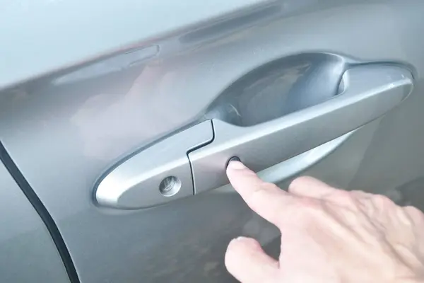 car door opened by finger pushing button and pulling